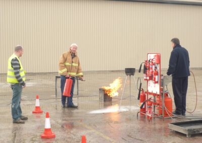 Fire safety trainer demonstrating how to use a fire extinguisher