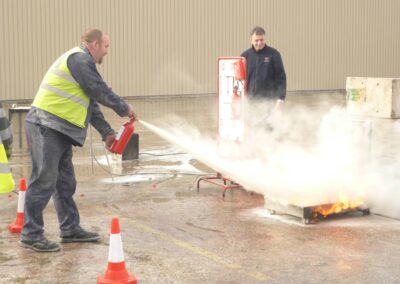 Hands on fire extinguisher practice during a fire safety course