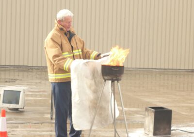 Fire safety trainer demonstrating how to use a fire blanket on a pan fire